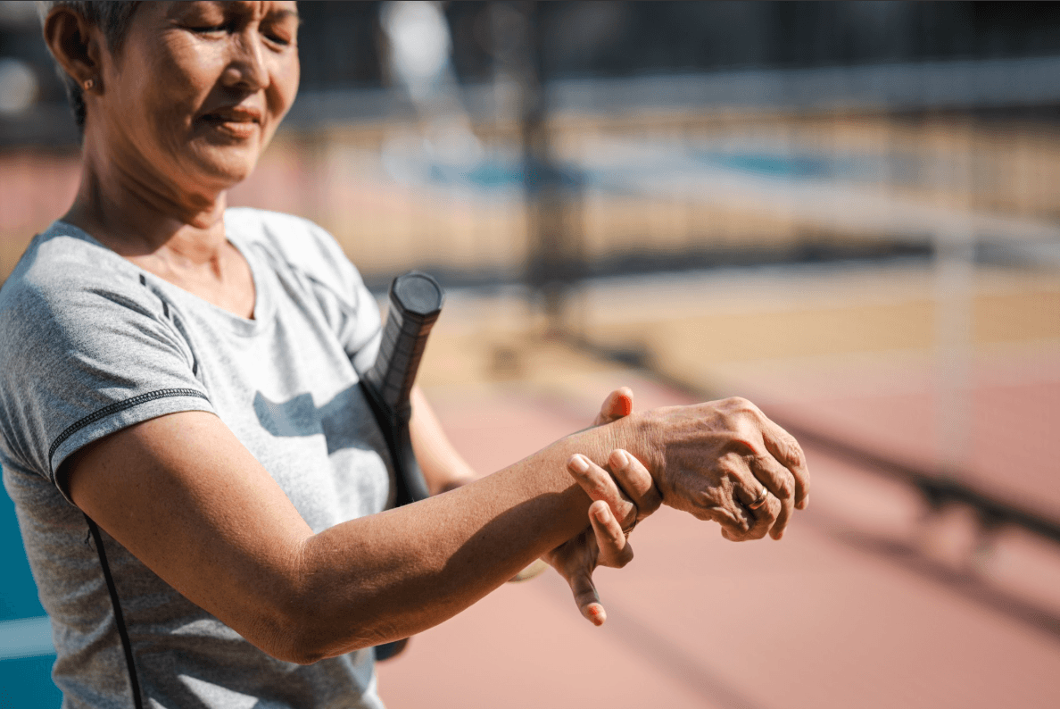 lady holding her hand on the tennis court 