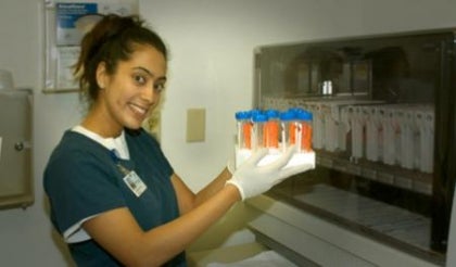 Technician holding a box with a set of test tubes